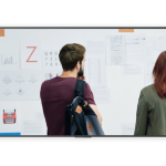 Airtame Collaboration A man and a woman standing in front of a whiteboard
